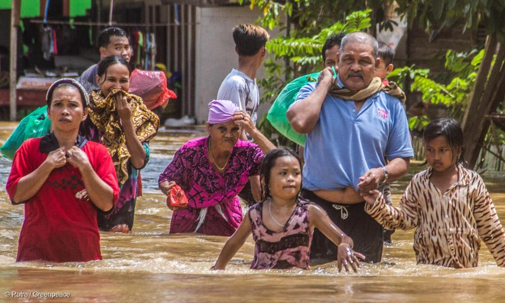 印尼南加里曼丹班加尔（Banjar）拉惹河村（Sungai Raya）的居民在水中跋涉，以迁出避难。